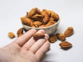 Isolated peeled and unpeeled almond on hand,floor and in ceramic bowl